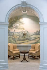 Sitting alcove with yellow chairs and scenic mural wallpaper